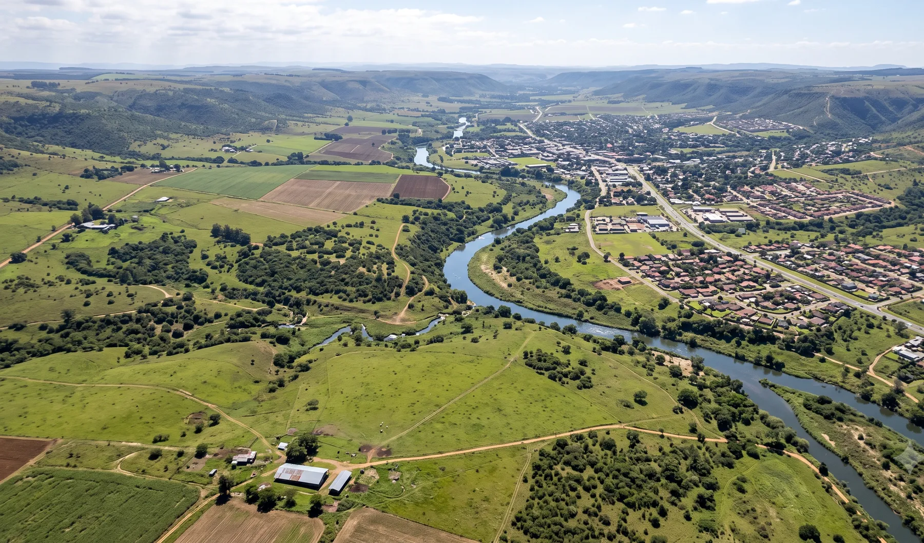 An elevated view of a river valley catchment showing the watercourse winding through mixed rural and urban land use.
