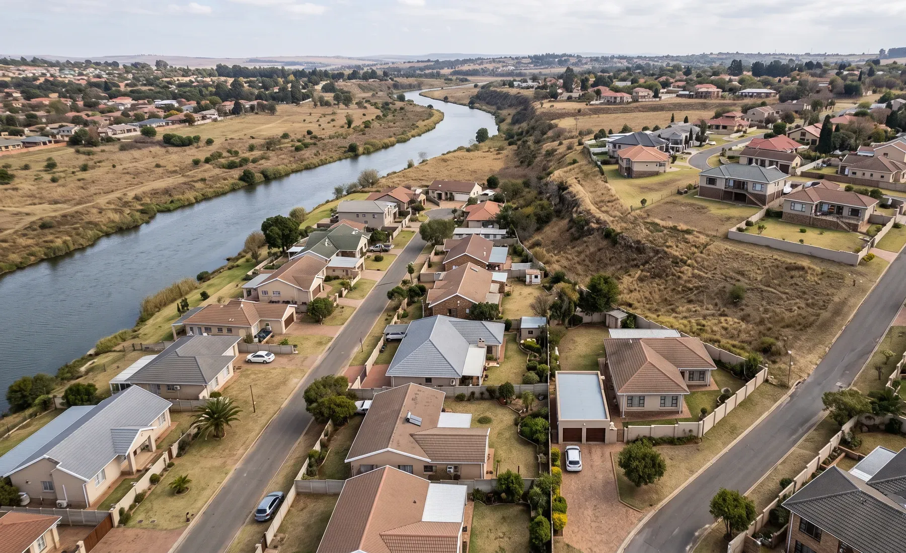 An aerial view of individual houses beside a river, showing which properties fall within the flood extent.