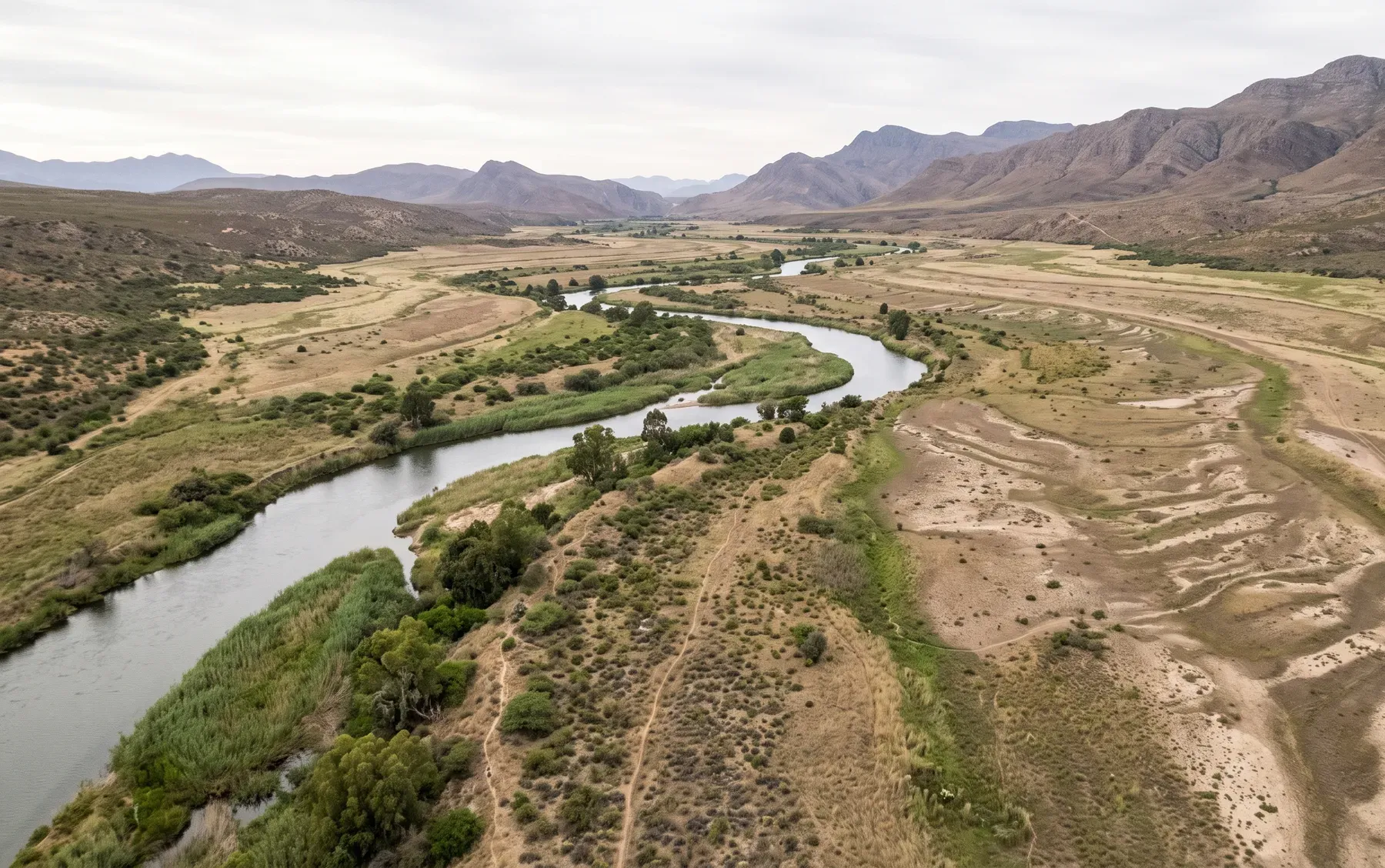 A wide watercourse showing a broad natural floodplain adjacent to the channel.