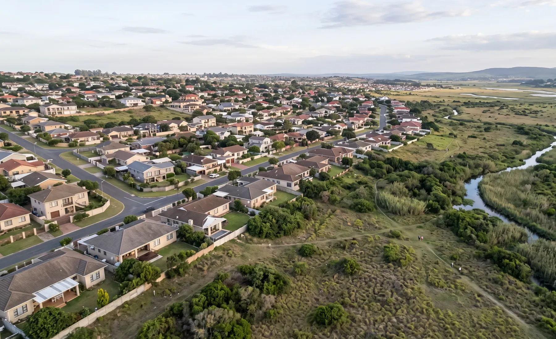 Aerial view of a mixed residential neighbourhood partially bordering a floodplain.