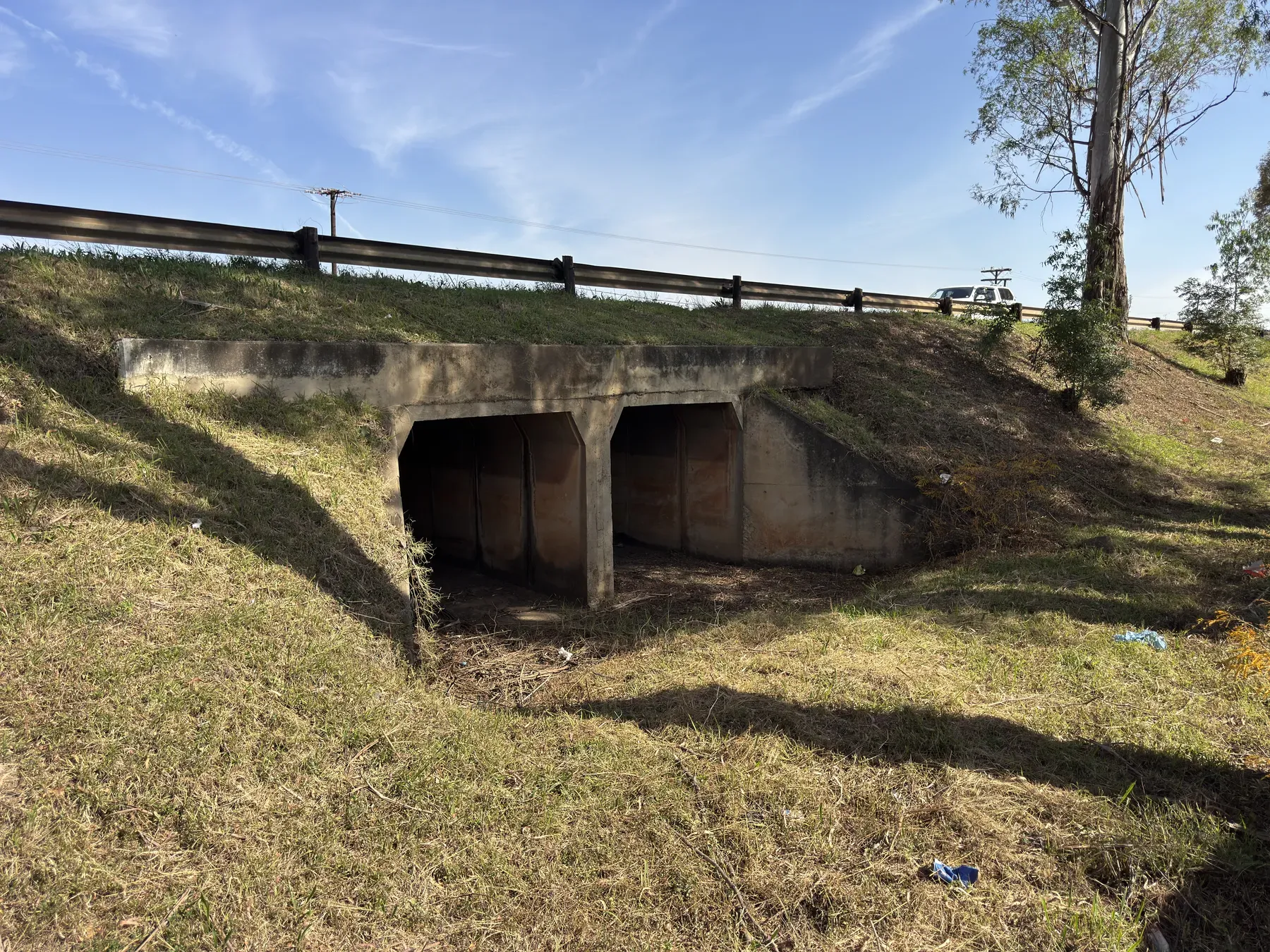 A twin-cell 2 m by 2 m concrete box culvert carrying a watercourse beneath a road.