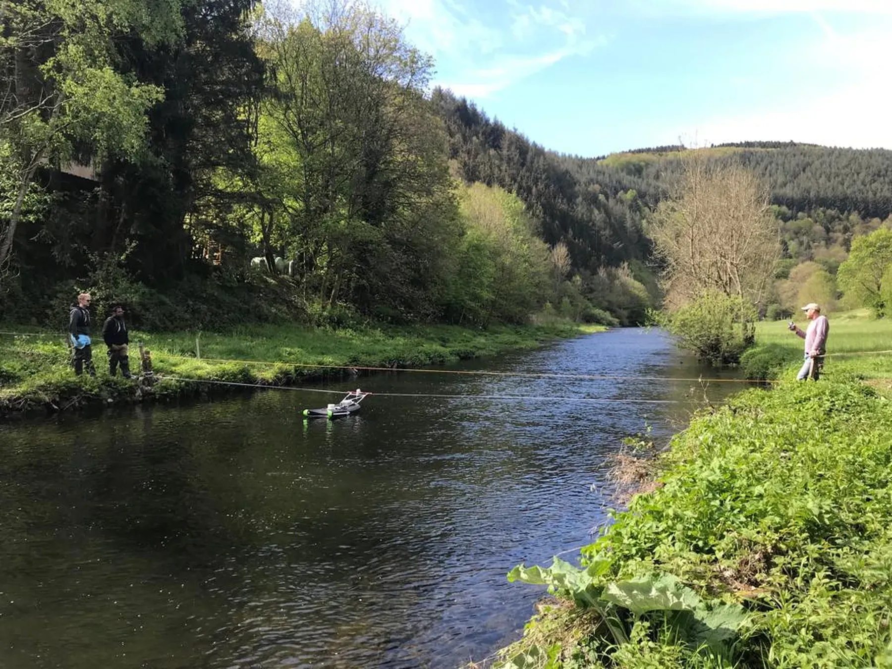 A remote-control survey boat carrying an echo sounder working a river section.